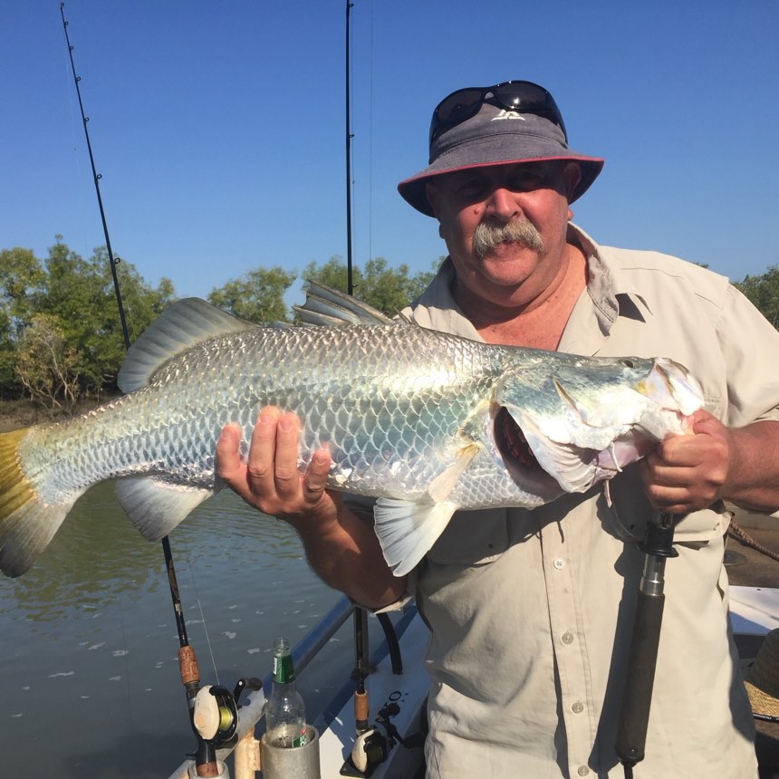 Angler on the water with a run-off barra