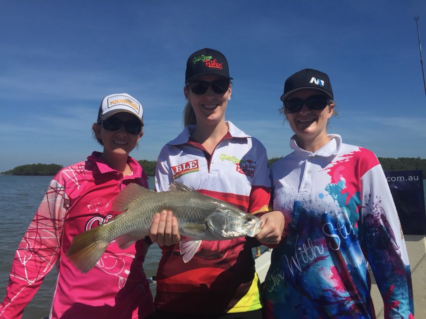 Three anglers sharing a laugh with their catch