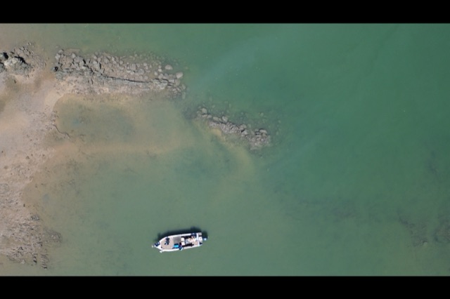 Top-down view of a boat working a rock bar and shallow structure