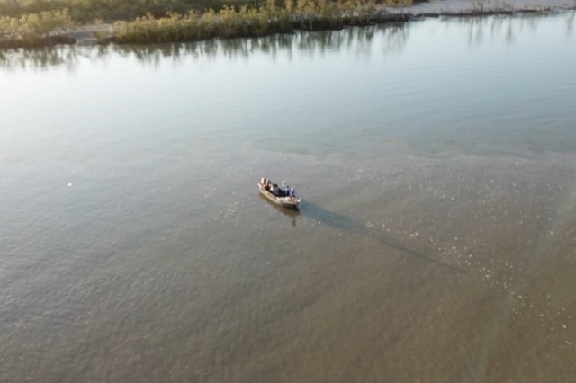 A boat working a glassed-off Top End river on a run-out tide