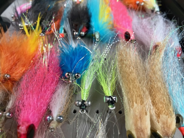 A tray of tropical saltwater flies tied for barra and pelagics