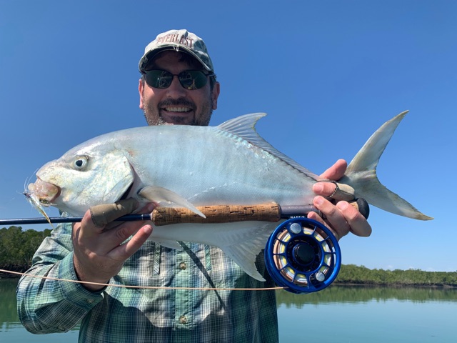 Fly angler with a golden trevally on the flats