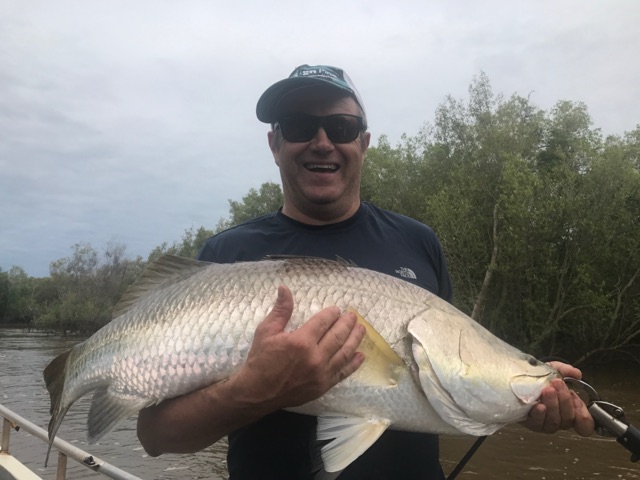 Barra held up against the mangrove wall