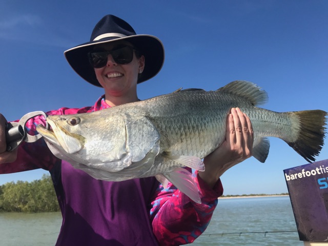 Angler with a big silver barra caught off the flats