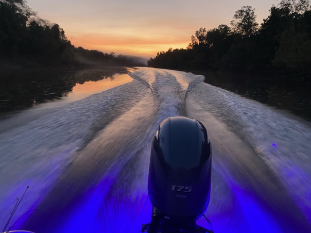 The boat&rsquo;s wake running out behind at sunset